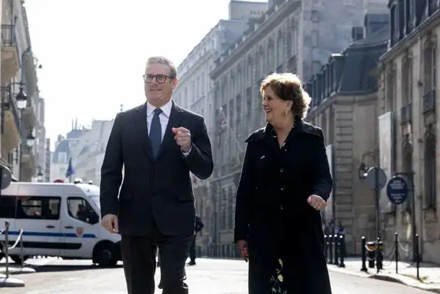 Keir Starmer and Menna Rawlings walk the streets of Paris, smiling and talking.